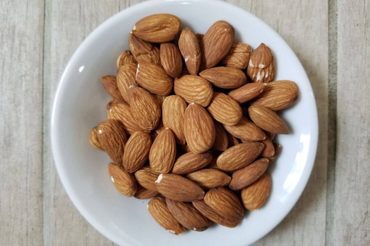 a pile of almonds in a white bowl.