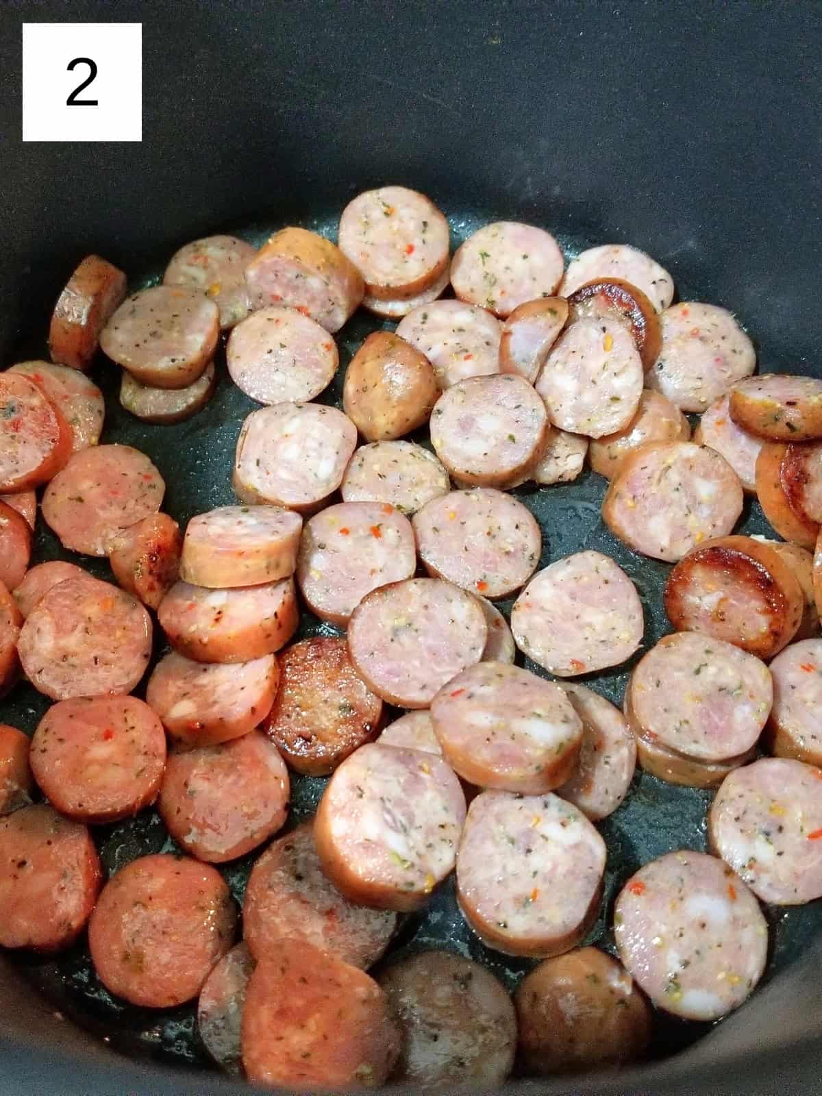 Sliced sausages in pot.