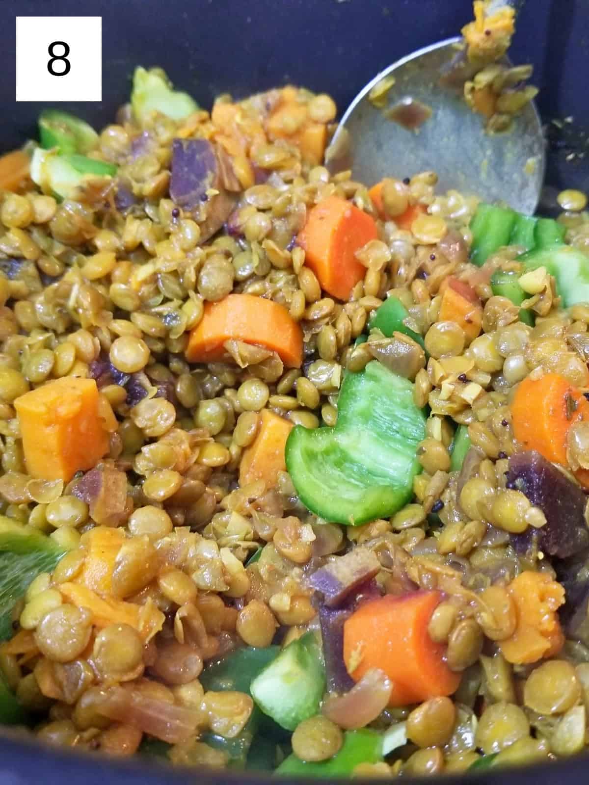 Cooked lentil stew with carrots and sweet potato in a pot.