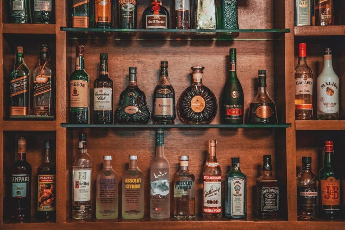 assorted liquor on brown wooden shelf.