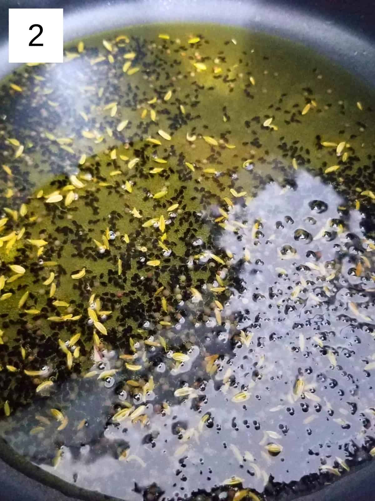 nigella, mustard, and fennel seeds in heated oil.