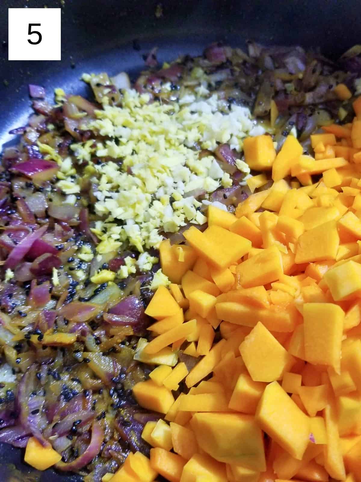 diced butternut squash, garlic, and ginger in an onion and seed mixture.