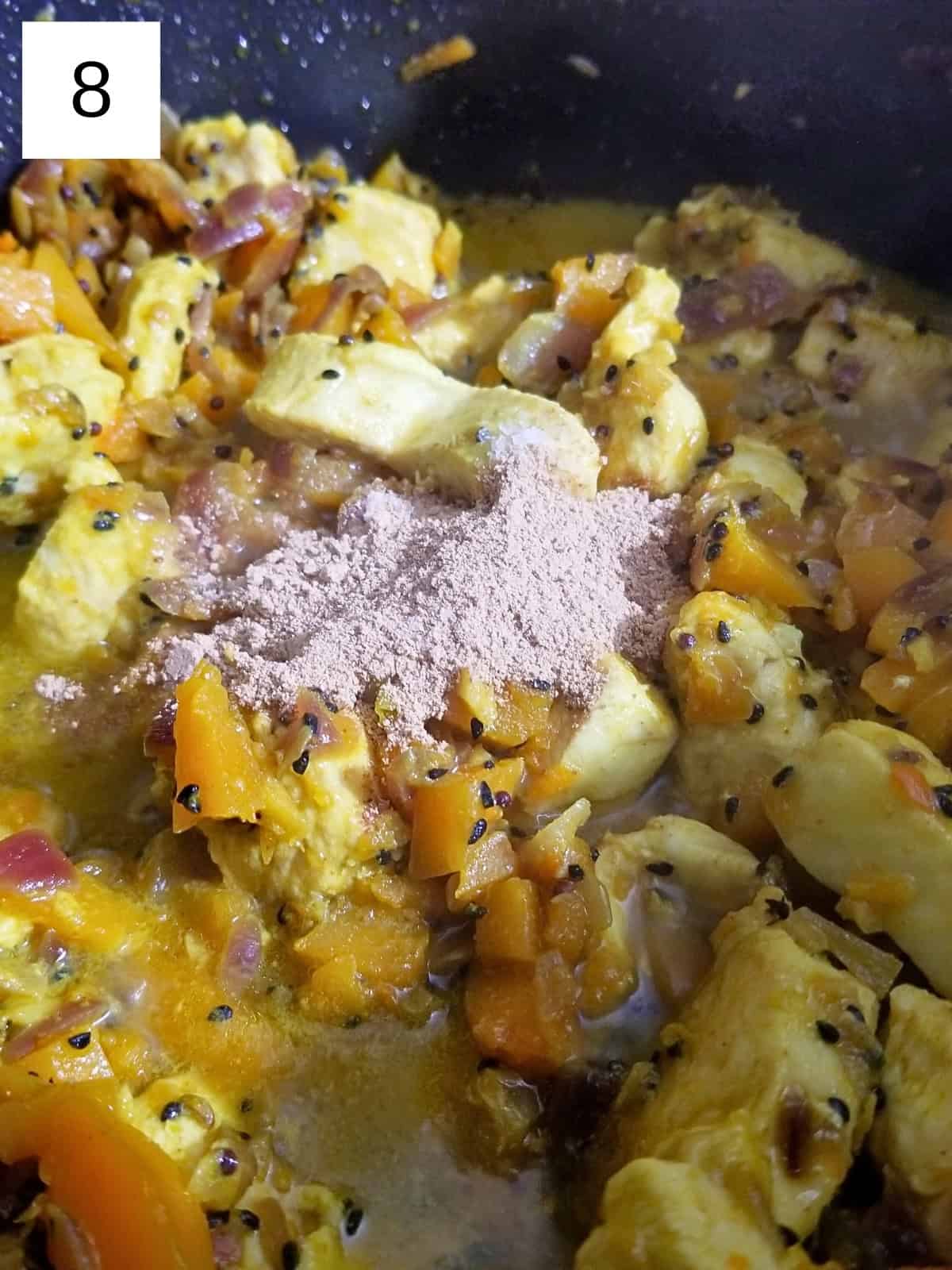 adding spices to a pan-stirred butternut squash and chicken mixture.