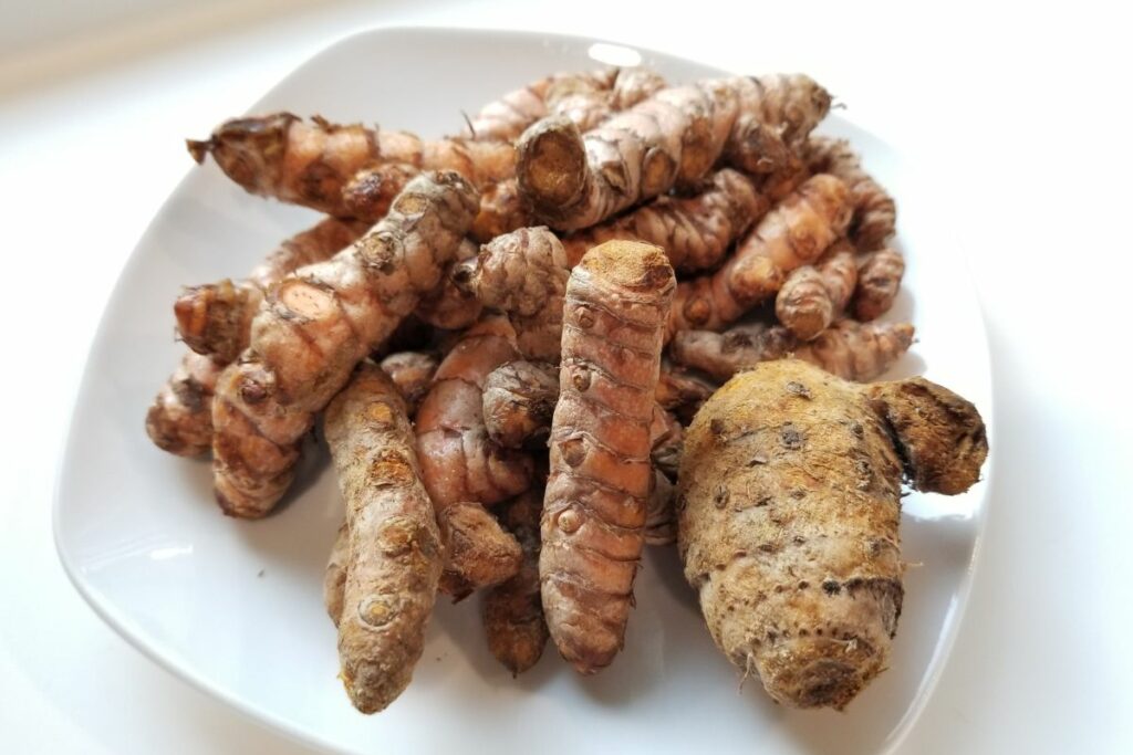 Pieces of turmeric root in a plate.