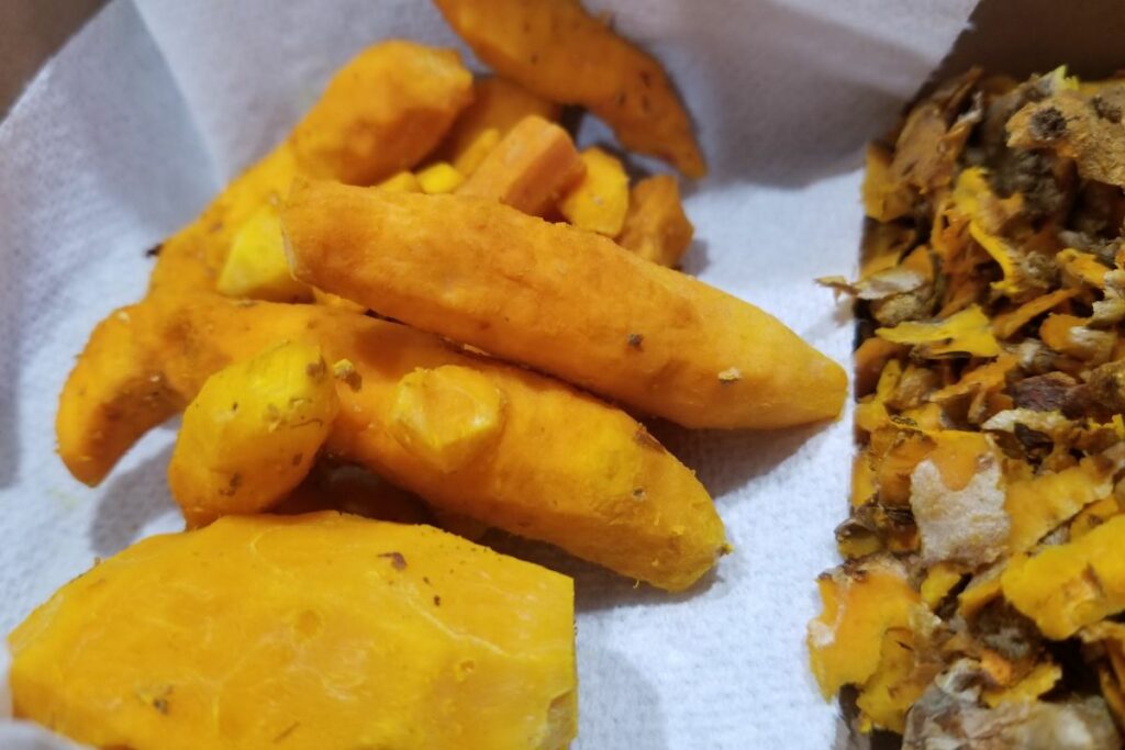 peeled turmeric roots on a kitchen towel.