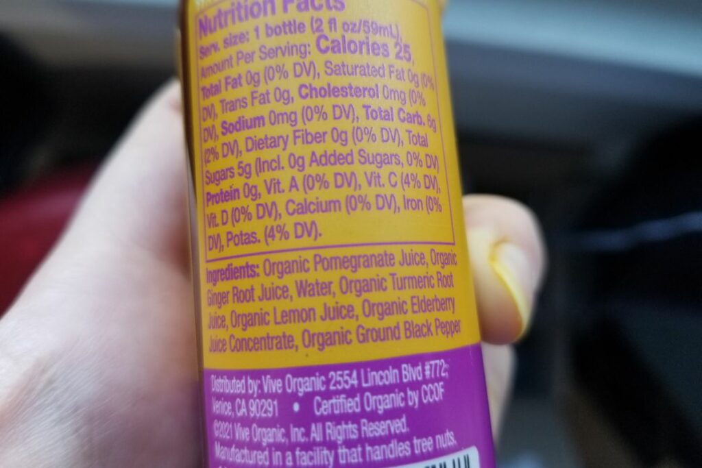 A person holding a turmeric vitamin nutrition facts.