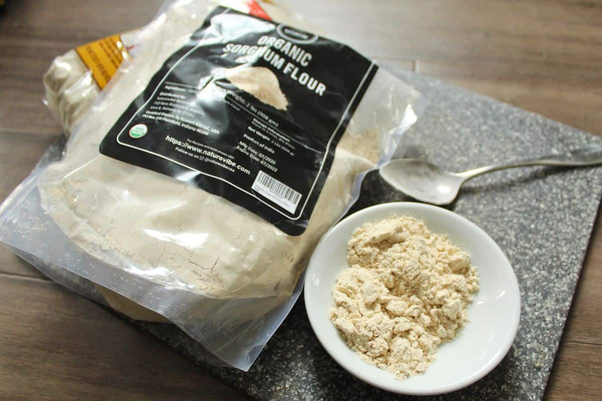 A pack of sorghum flour next to a bowl of sorghum flour.