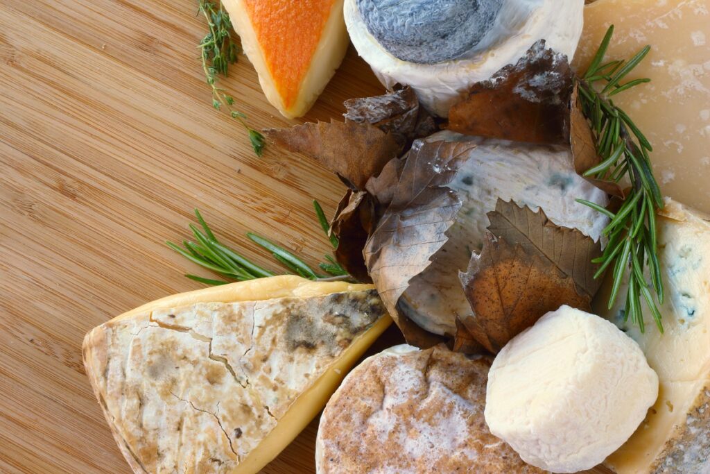 high histamine cheeses (aged & fermented) on a wooden chopping board.