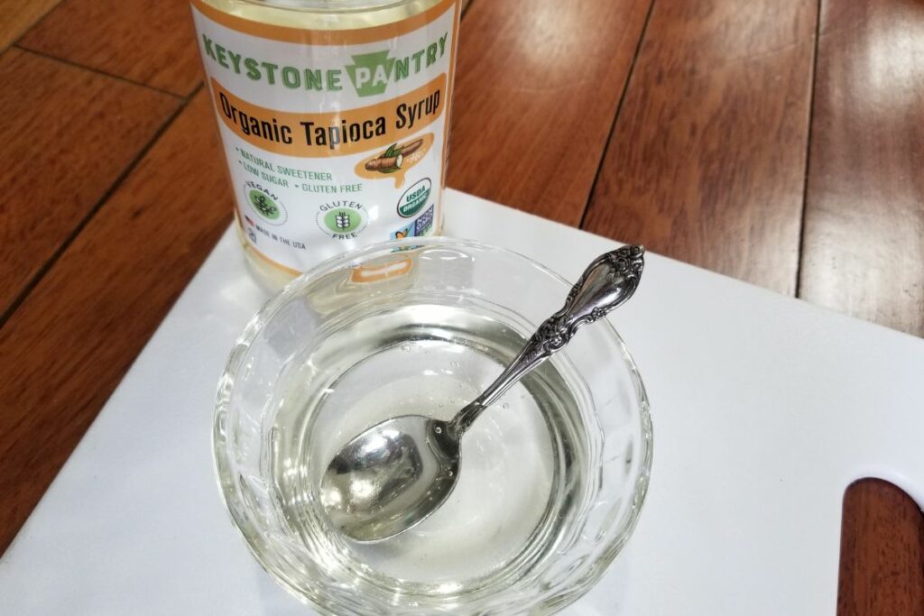 A bowl of tapioca syrup next to a bottled organic tapioca syrup. 