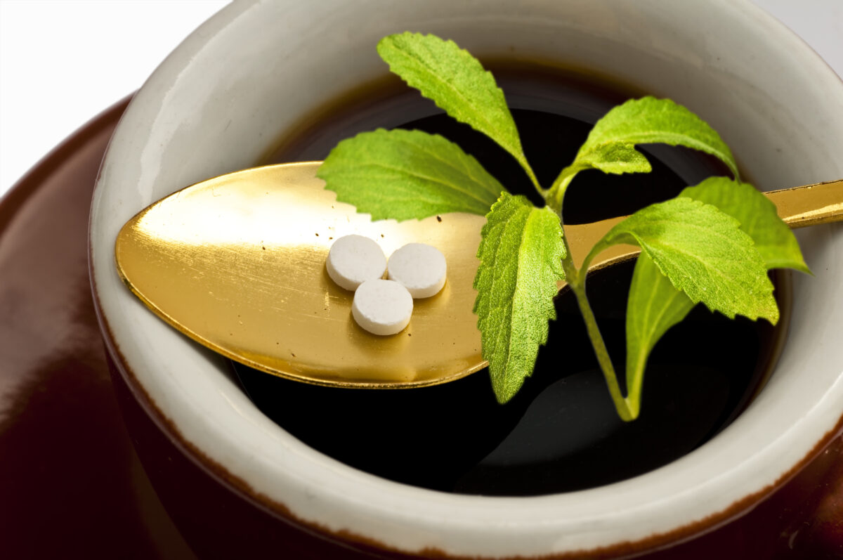 Stevia tablet next to a stevia plant.