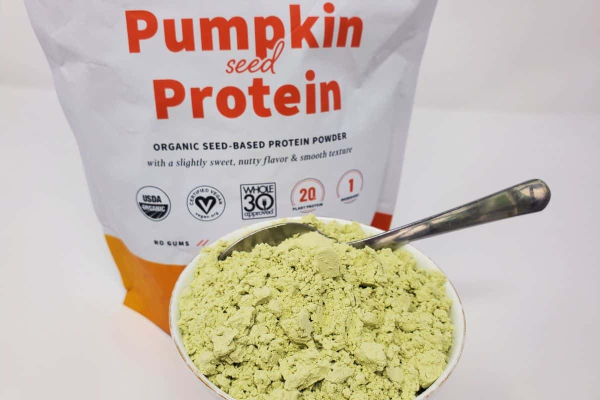 a mug full of pumpkin seed protein powder.