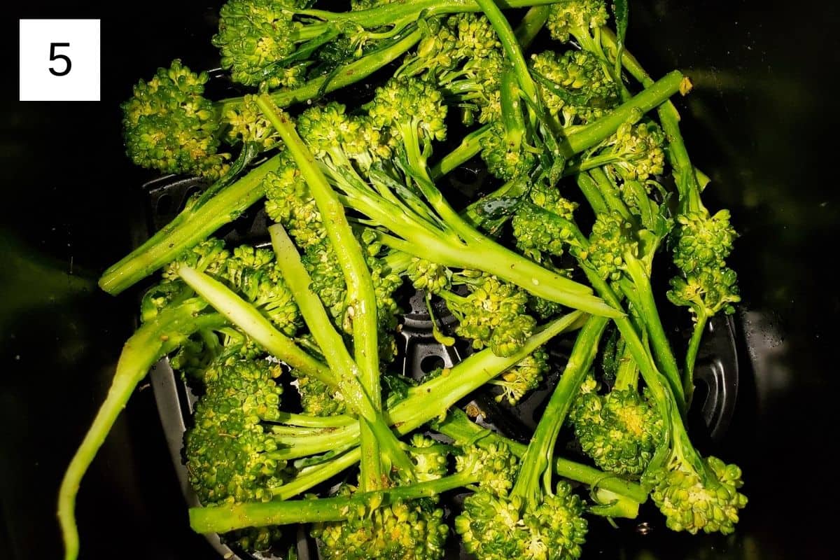 seasoned broccolini in an air fryer.