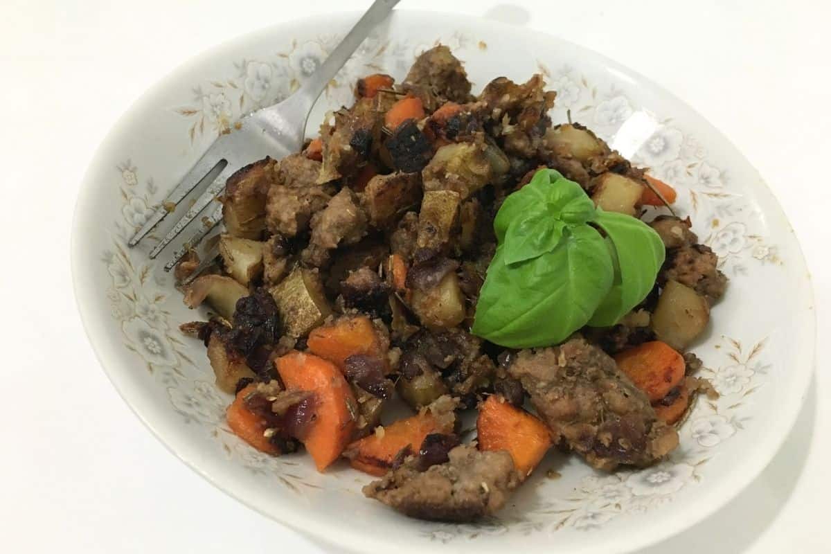 rosemary garlic lamb skillet topped with fresh basil.