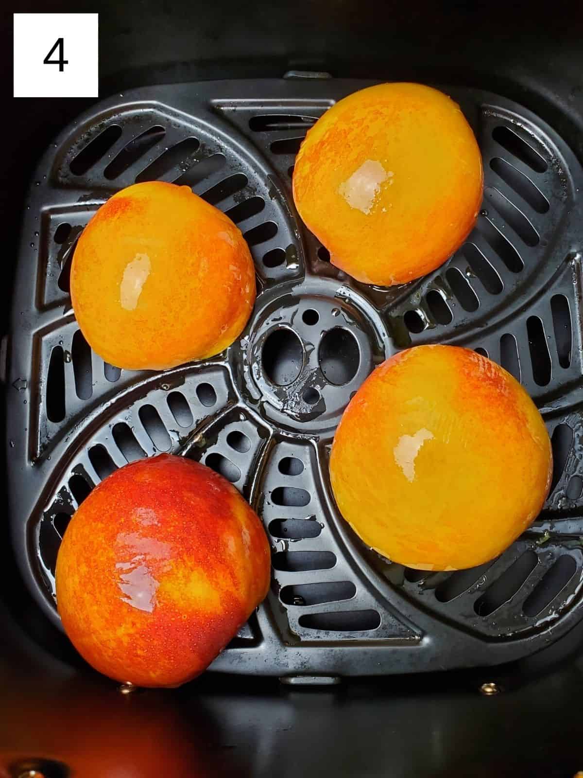four halves of peaches in an air fryer