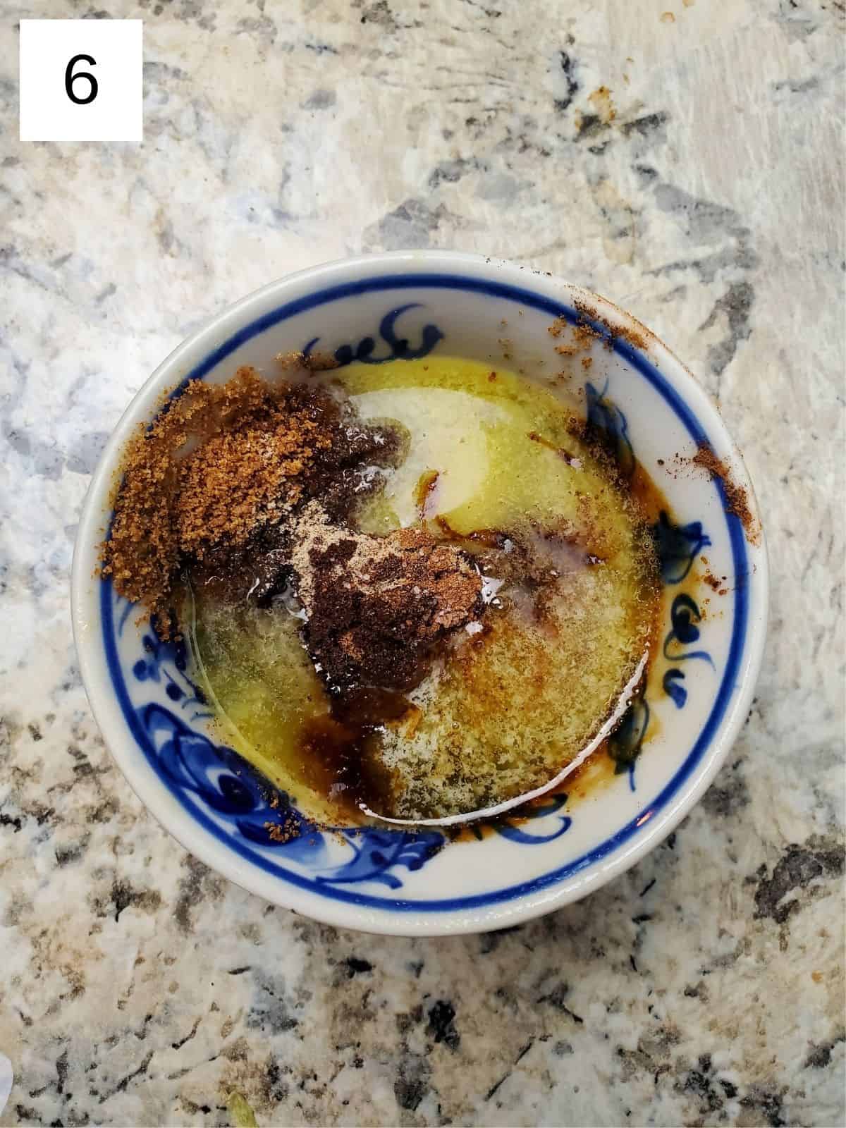 spiced butter mixture in a bowl with melted butter, coconut sugar, cardamom, and vanilla