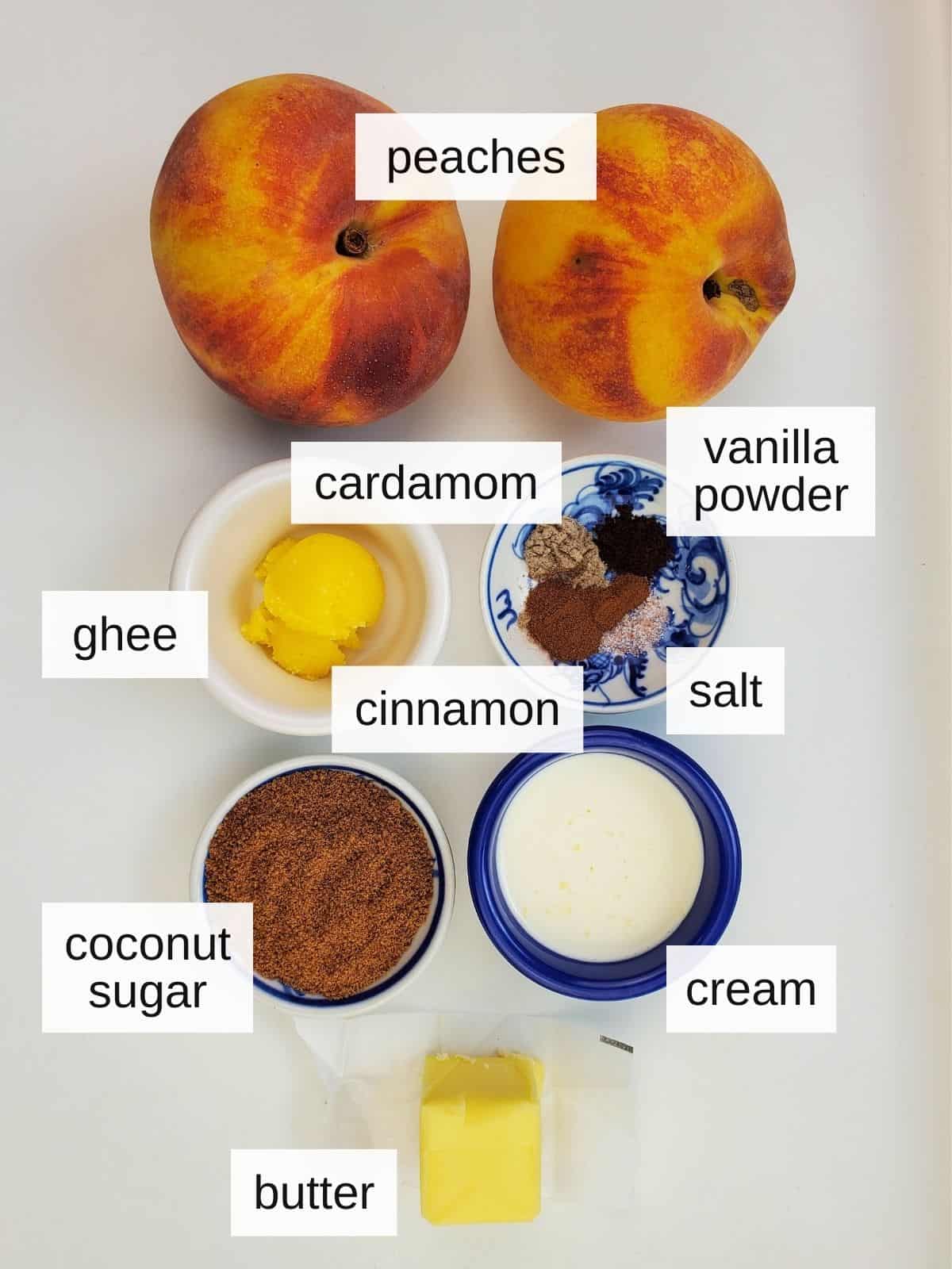 ingredients for caramelized peaches in air fryer, including peaches, cardamom, vanilla powder, ghee, cinnamon, salt, coconut sugar, cream, and butter