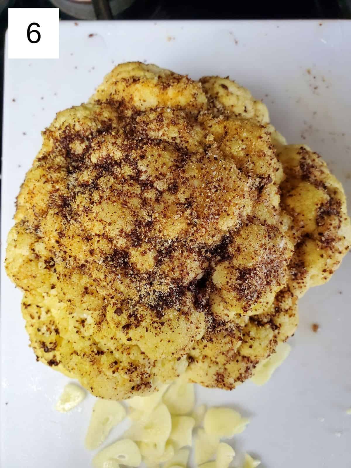 whole cauliflower coated with oil, garlic powder, sumac, and salt.