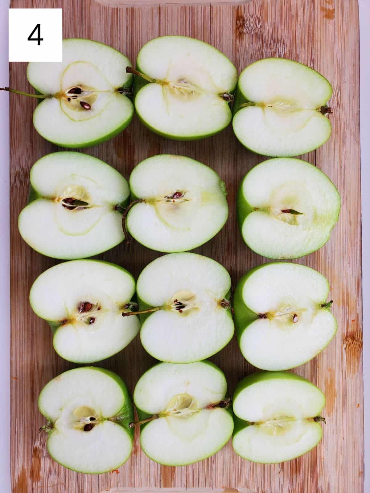 halves of apples on a wooden chopping board.