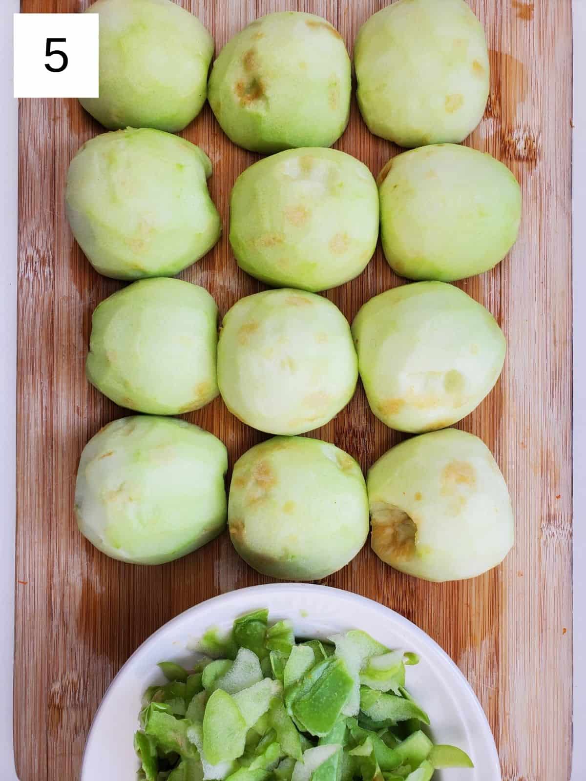 peeled halves of apples on a wooden chopping board.