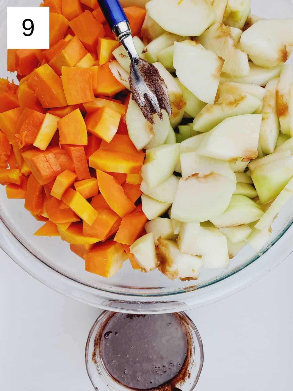 a bowl full of slices of butternut squash and apples, and a glass of seasoning mixture.