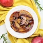 cooked caramelized apples on a white plate.
