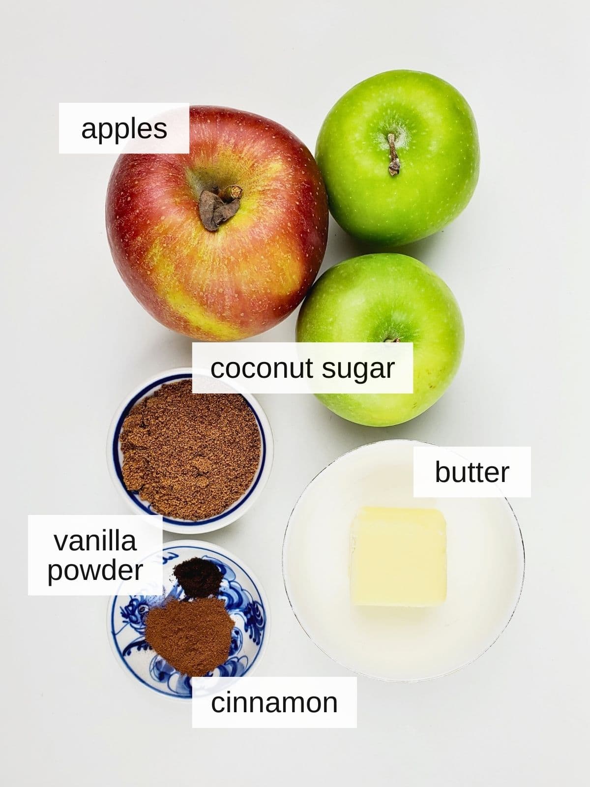 ingredients for caramelized apples, including apples, coconut sugar, butter, vanilla powder, and cinnamon.