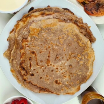 a well-cooked chestnut flour crepes on a plate, and various toppings and fillings to choose from.