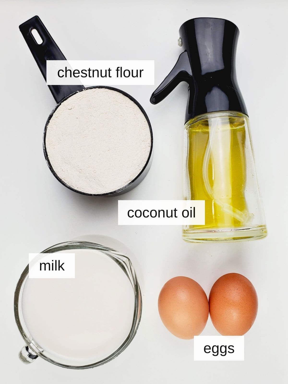 ingredients for chestnut flour crepes, including chestnut flour, coconut oil, eggs, and milk.