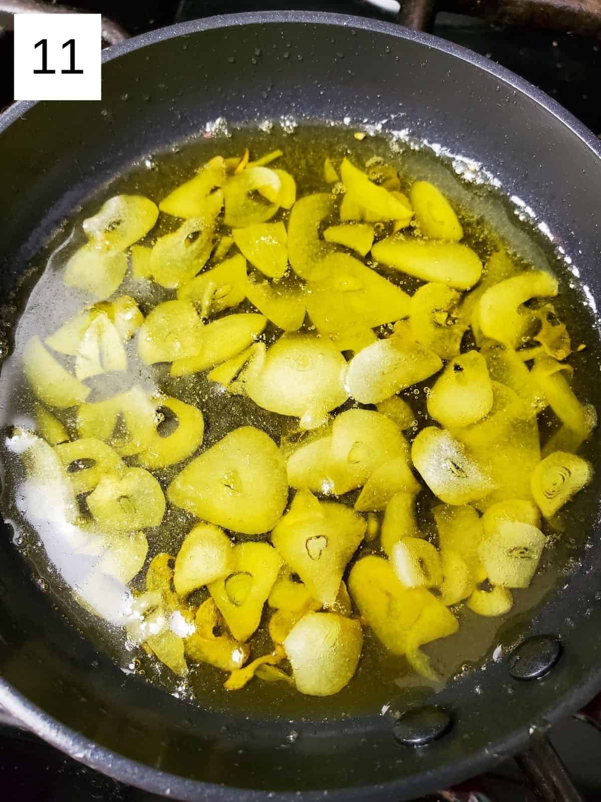 sautéing the garlic slices in a pot using avocado oil.
