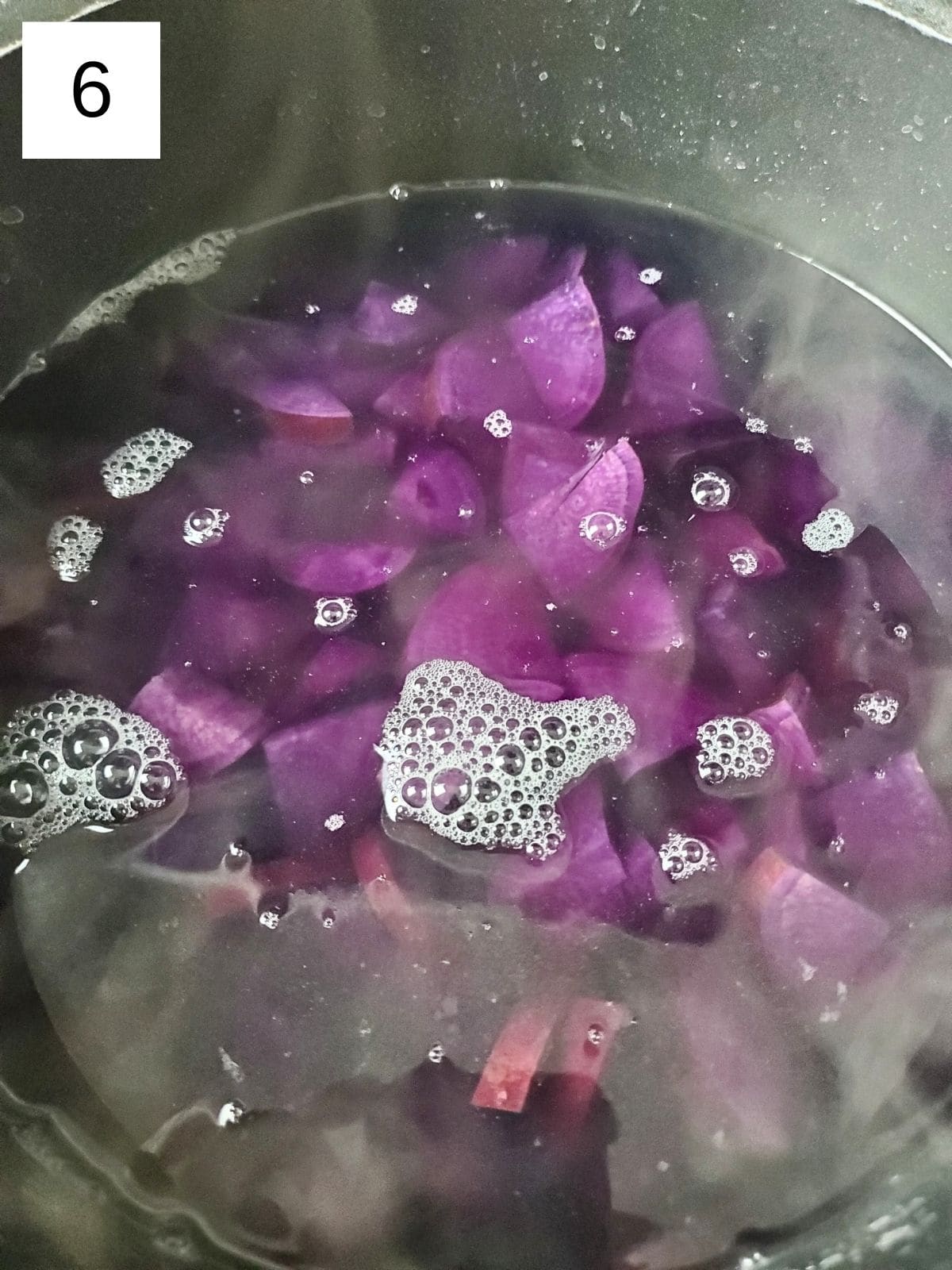 slices of purple sweet potatoes in a boiling pot of salted water.