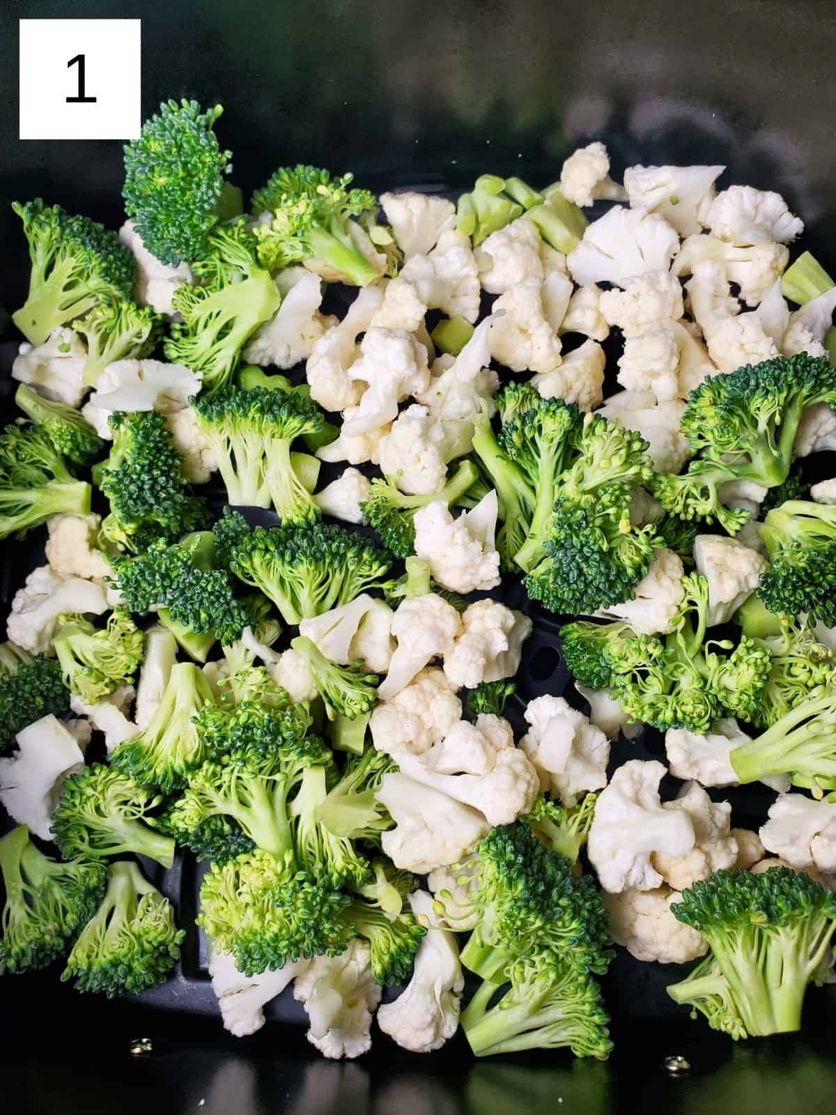 fresh broccoli and cauliflower, chopped into small pieces, in an air fryer.