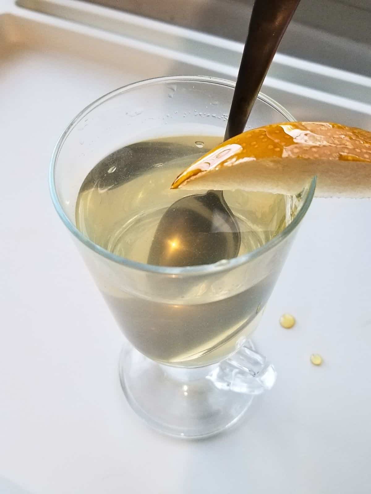 Asian pear tea, topped with a slice of pear, in a glass.