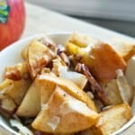 spiced baked apples topped with coconut chips in a bowl.