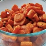 baked seasoned carrot slices in a glass bowl.