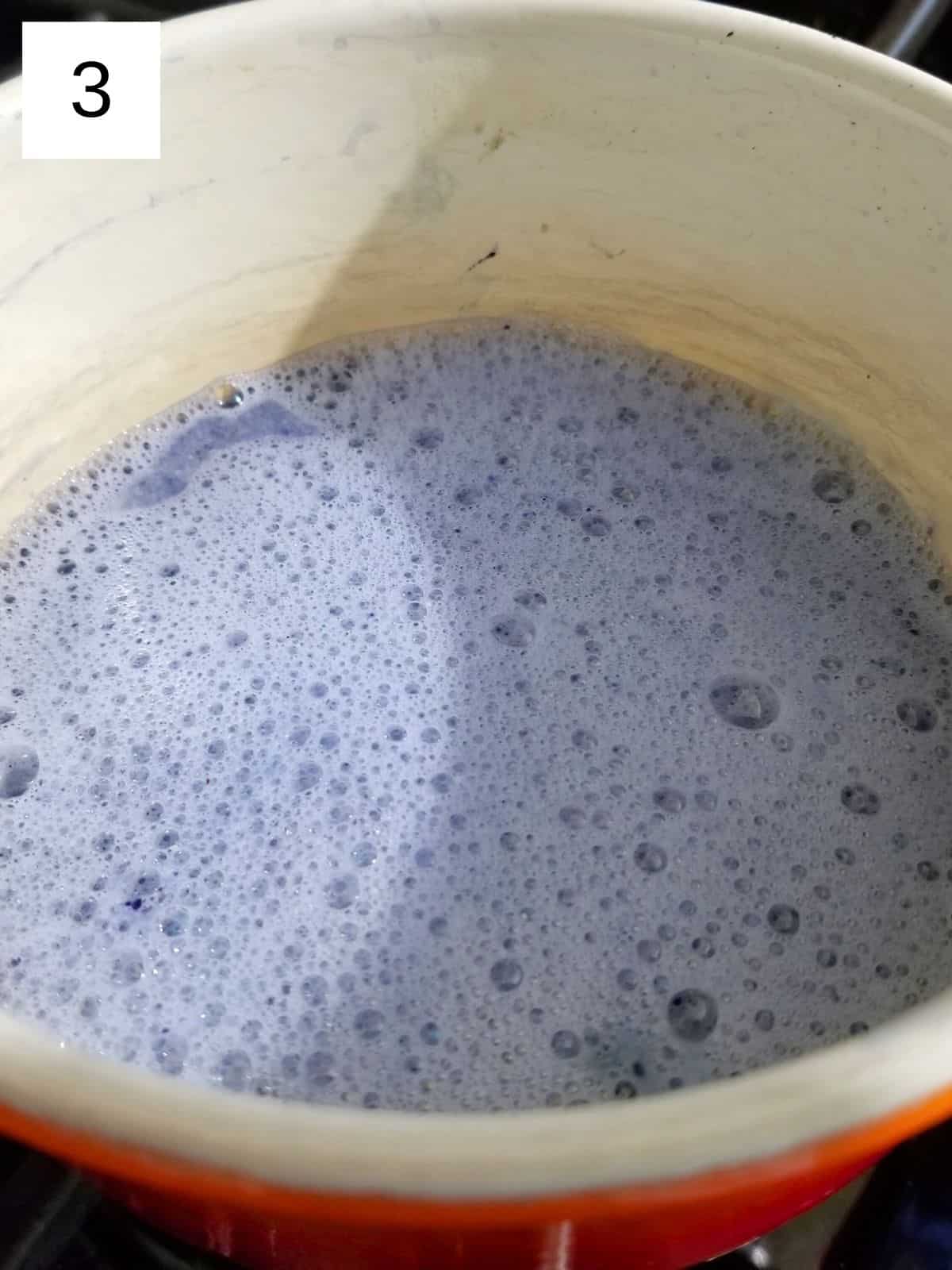 a mixture of blue matcha powder and milk in a pot.