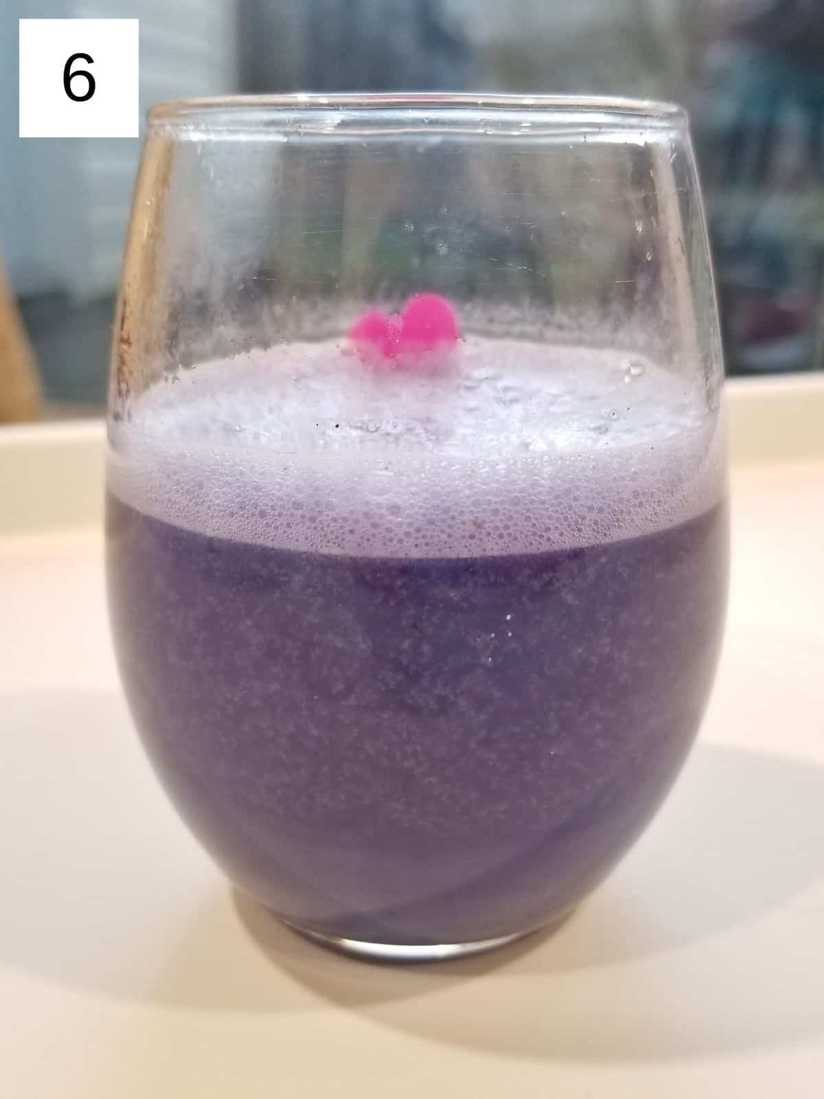 butterfly pea tea latte in a clear glass.