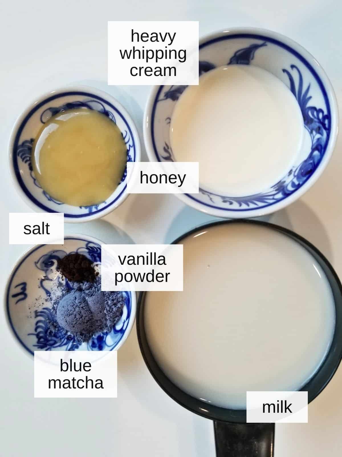 butterfly pea (blue matcha) latte recipe ingredients, including heavy whipping cream, honey, salt, vanilla powder, milk, and blue match.