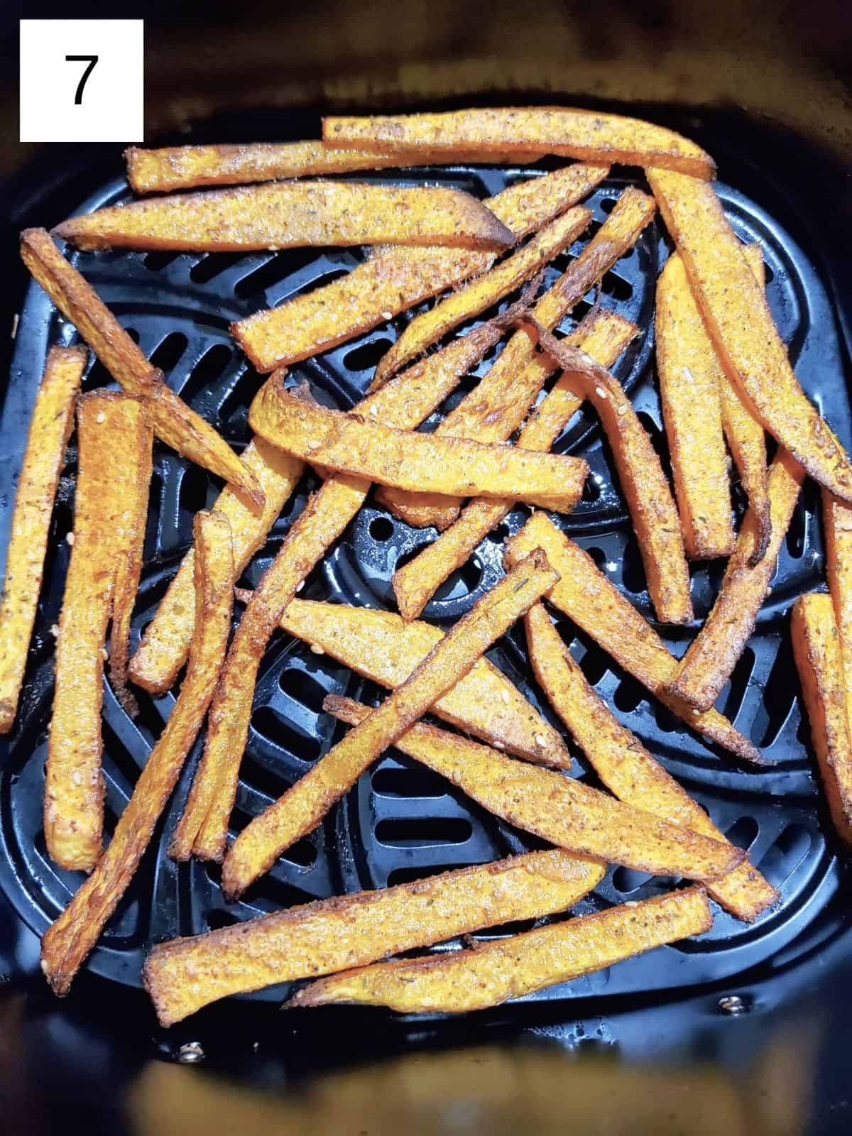 cooked butternut squash slices in an air fryer.