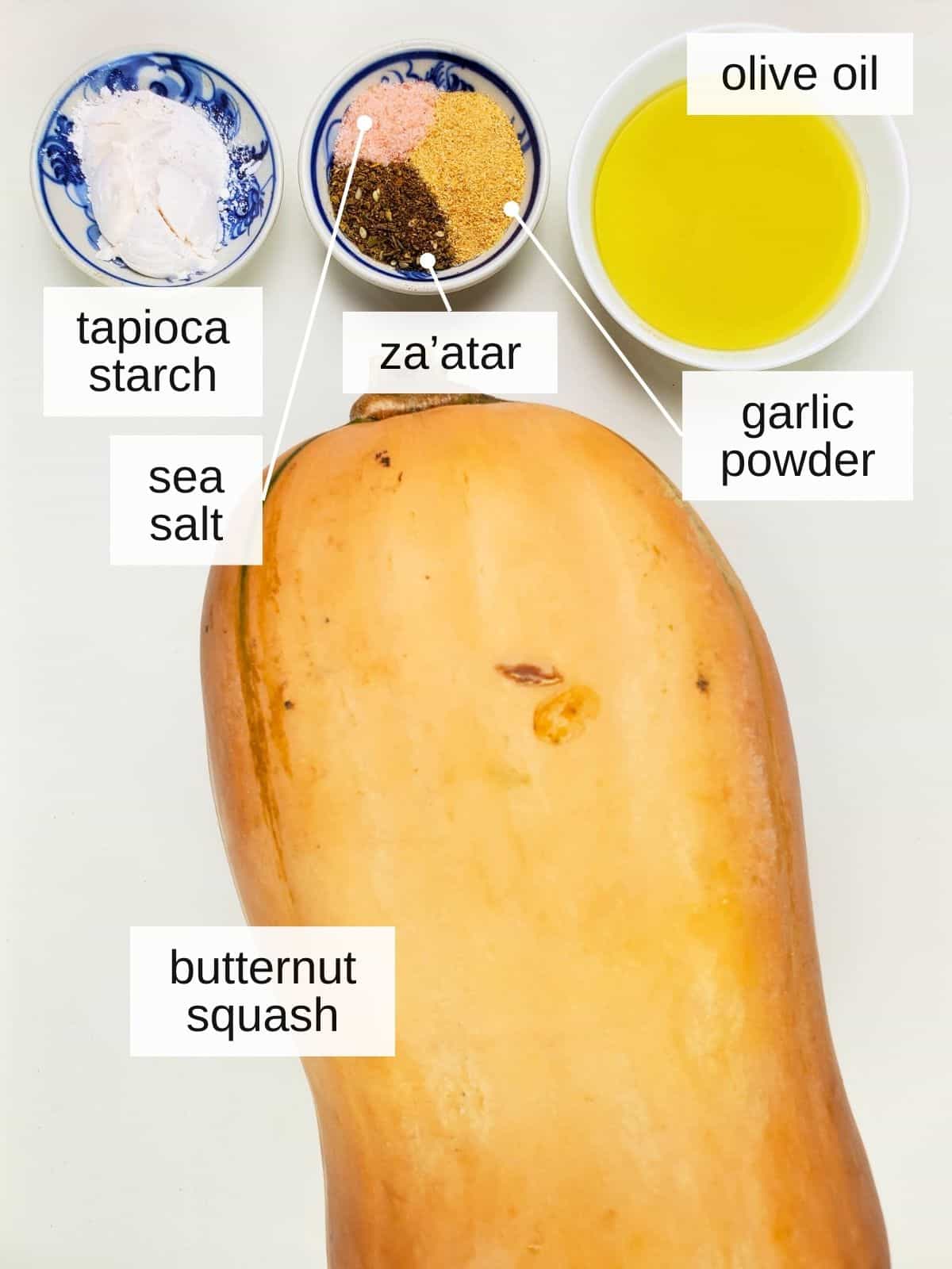 ingredients for butternut squash fries in air fryer, including tapioca starch, sea salt, za'atar, olive oil, garlic powder, and butternut squash.