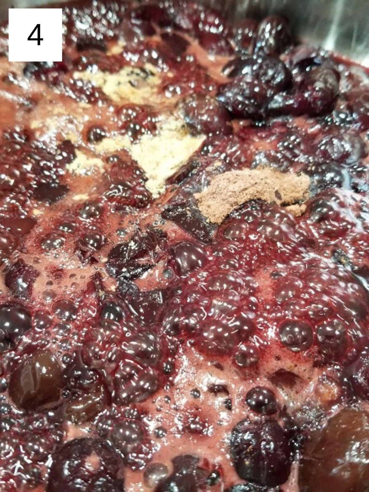 seasonings on top of crushed cherries in a saucepan.