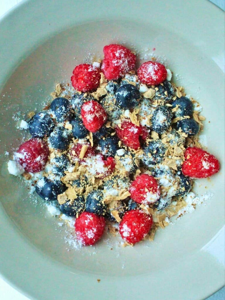 mixed berries, coconut milk powder, and monk fruit in a bowl.