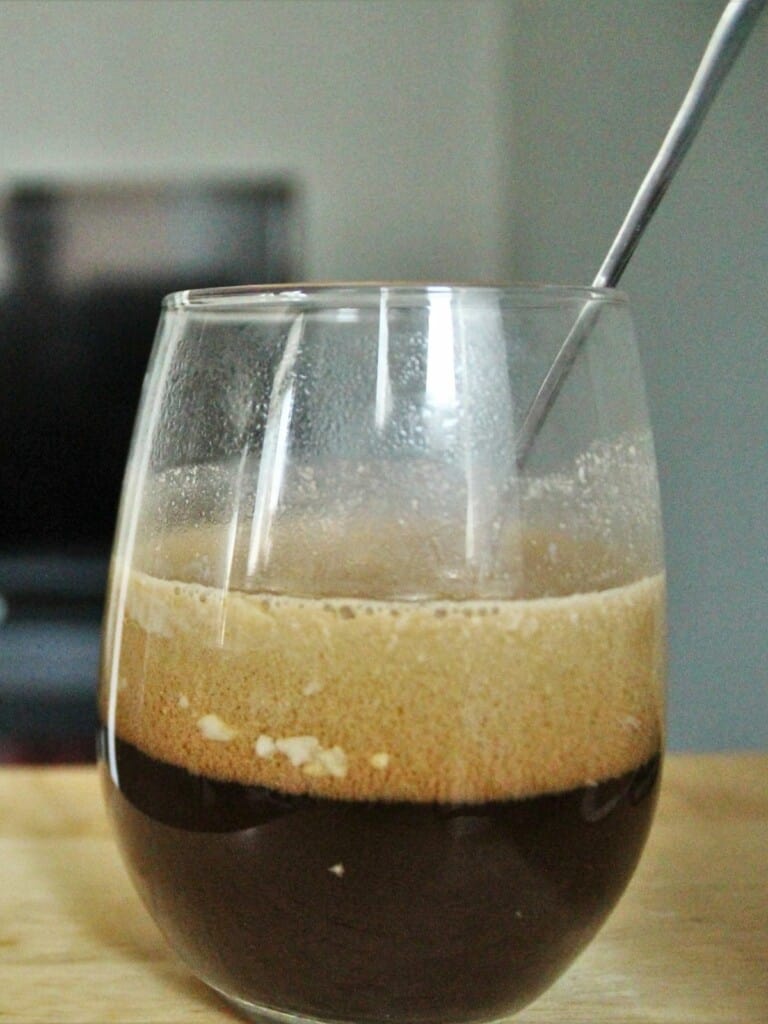 a glass of coconut milk coffee on a table.