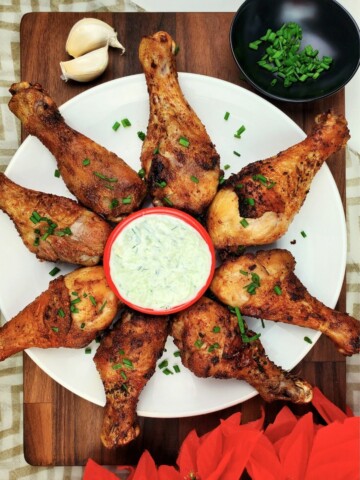 air-fried chicken legs, served with sauce, on a white plate.