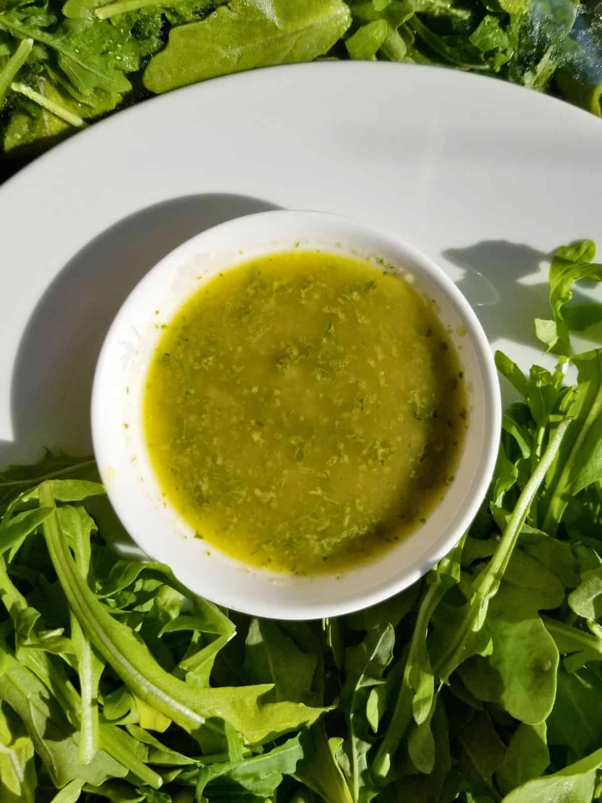 herbs salad dressing with garlic with a variety of herbs on the background.