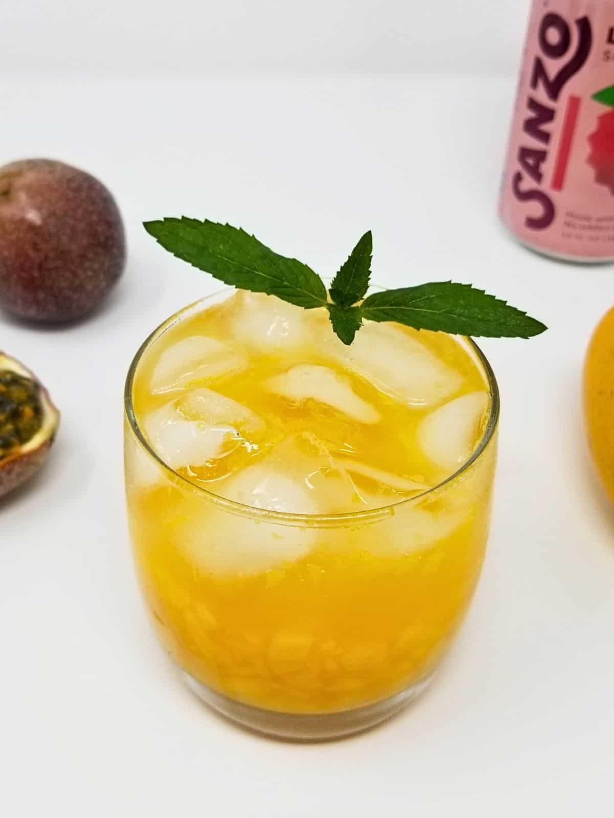 mango passion fruit mocktail on a drinking glass served with ice.