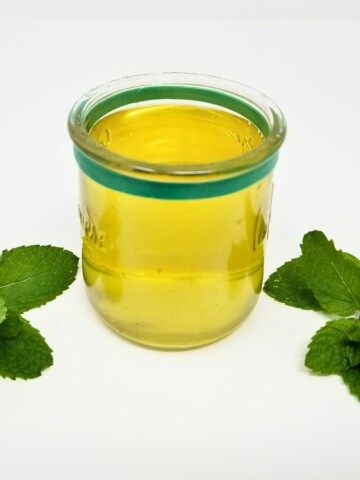 mint simple syrup in a glass.