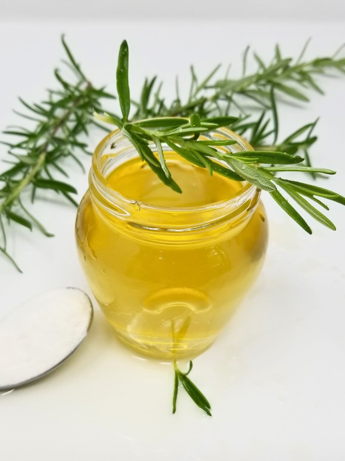 rosemary simple syrup in a glass container.