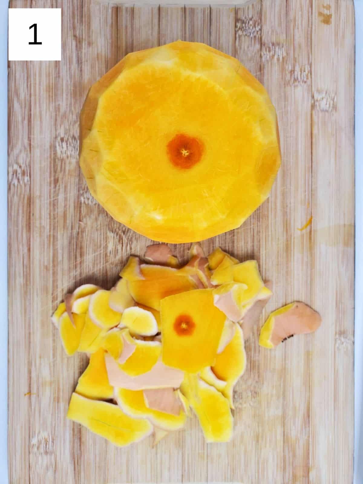 peeled butternut squash on a wooden chopping board.