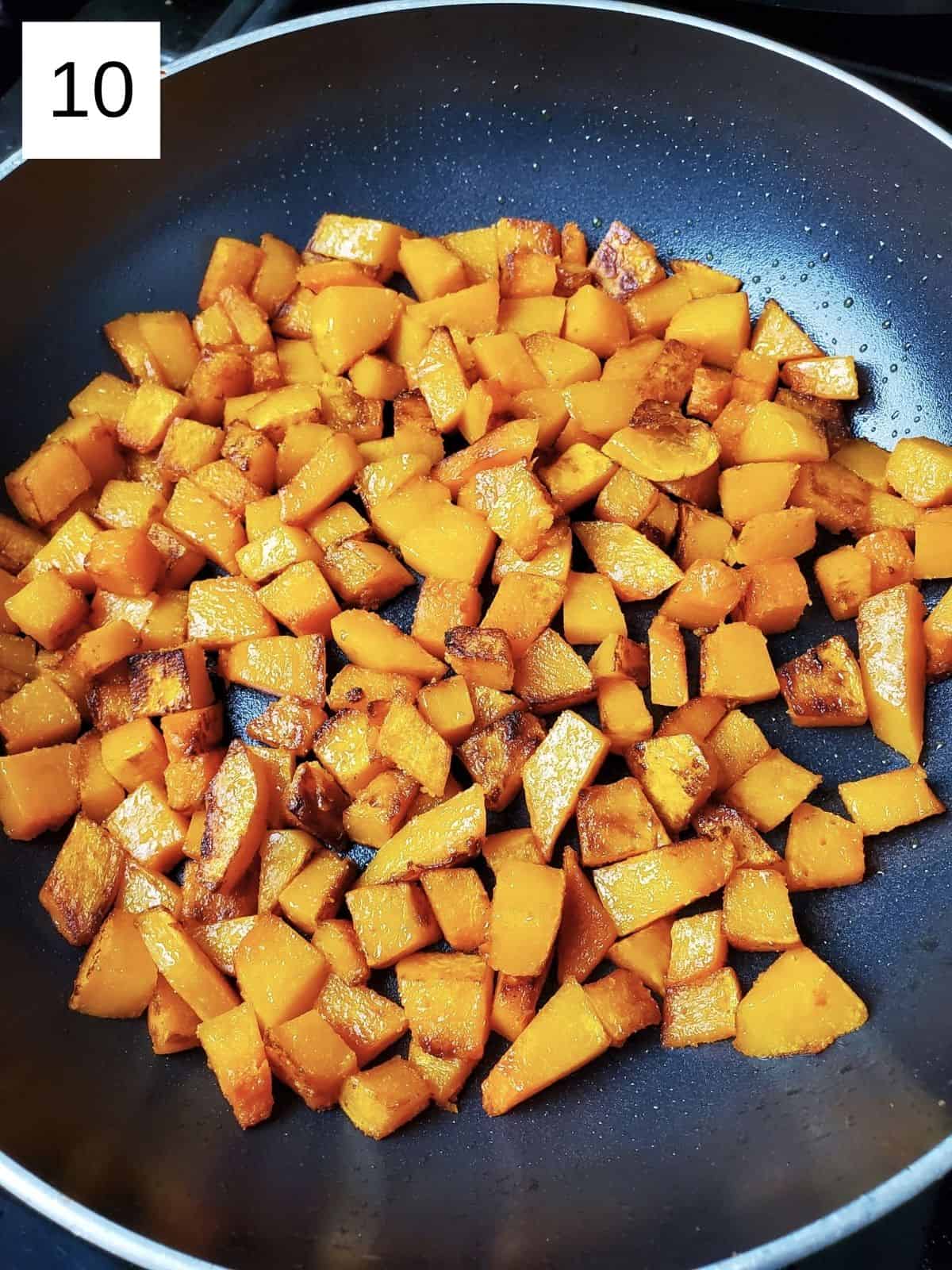 seasoned and sautéed butternut squash cubes in a pan.