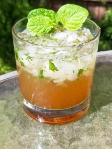 virgin mint julep mocktail in a glass topped with fresh mint leaves.